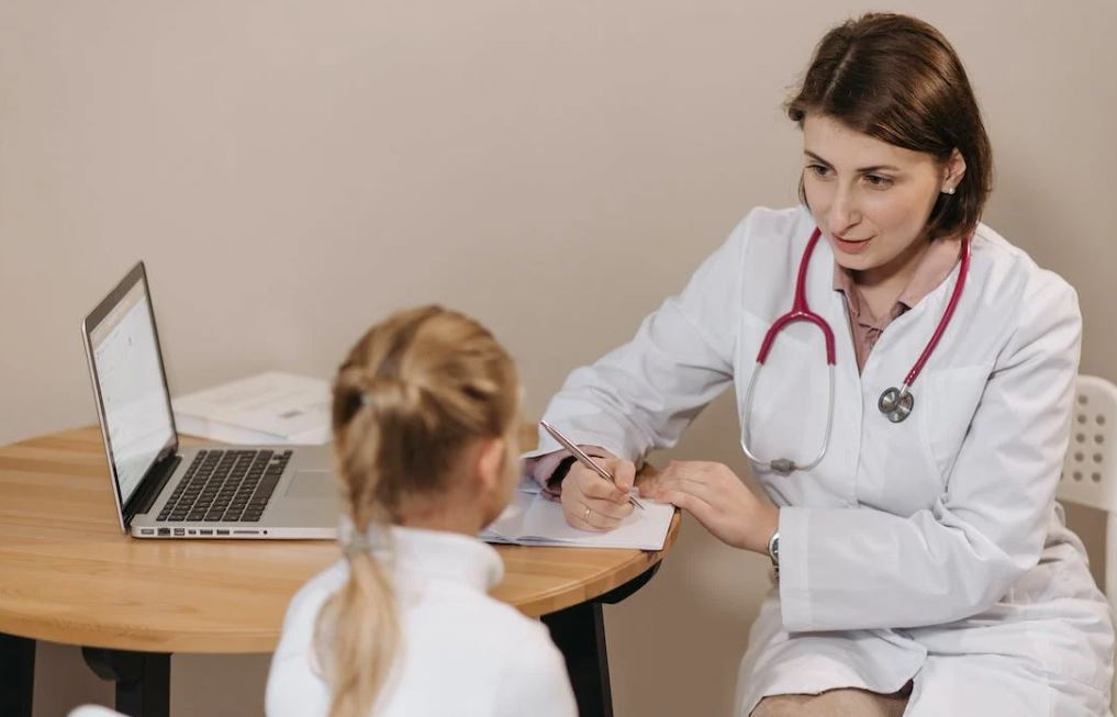A doctor talking to a little girl